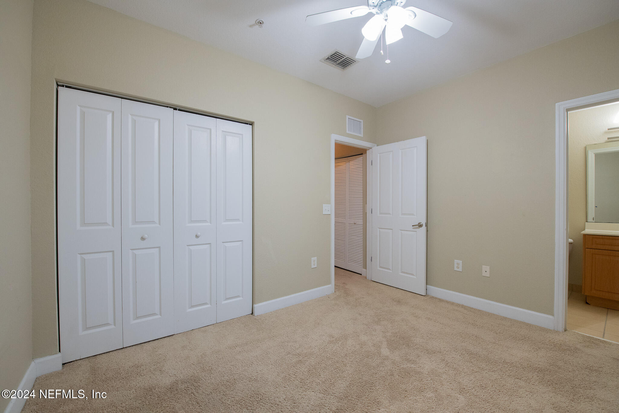 9745 Touchton Road, Unit 1922 Jacksonville, FL 32246 - Photo 14 of 26 an empty room with a chandelier fan and closet area