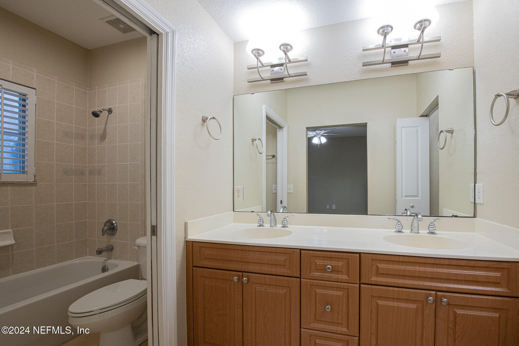 9745 Touchton Road, Unit 1922 Jacksonville, FL 32246 - Photo 19 of 26 a bathroom with a granite countertop sink a toilet and shower
