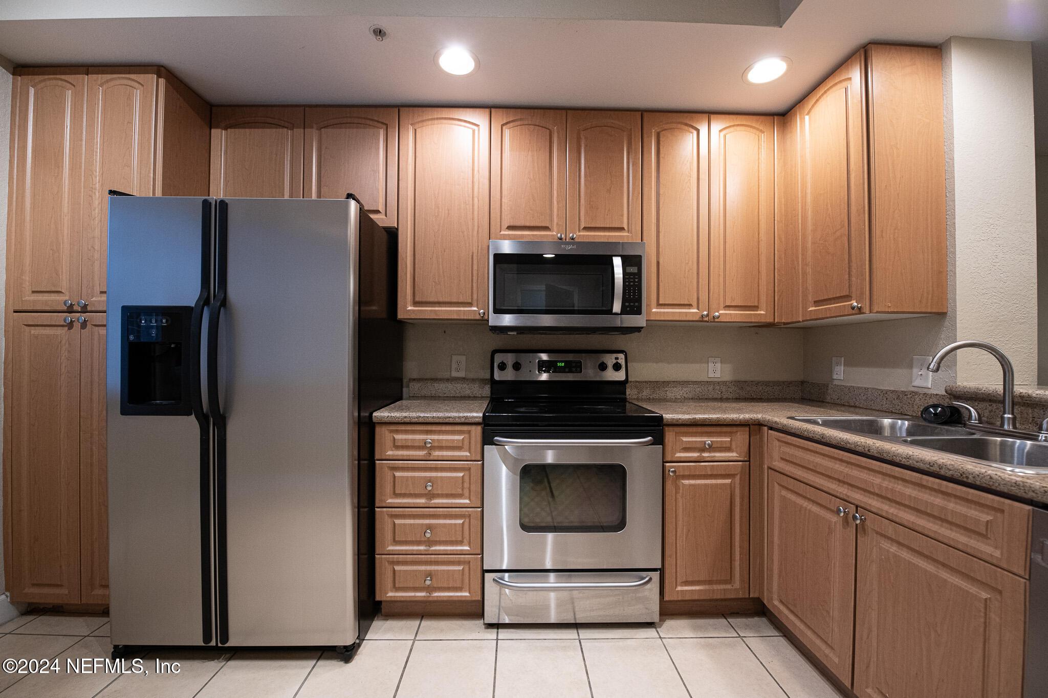 9745 Touchton Road, Unit 1922 Jacksonville, FL 32246 - Photo 5 of 26 a kitchen with stainless steel appliances granite countertop a refrigerator stove and sink