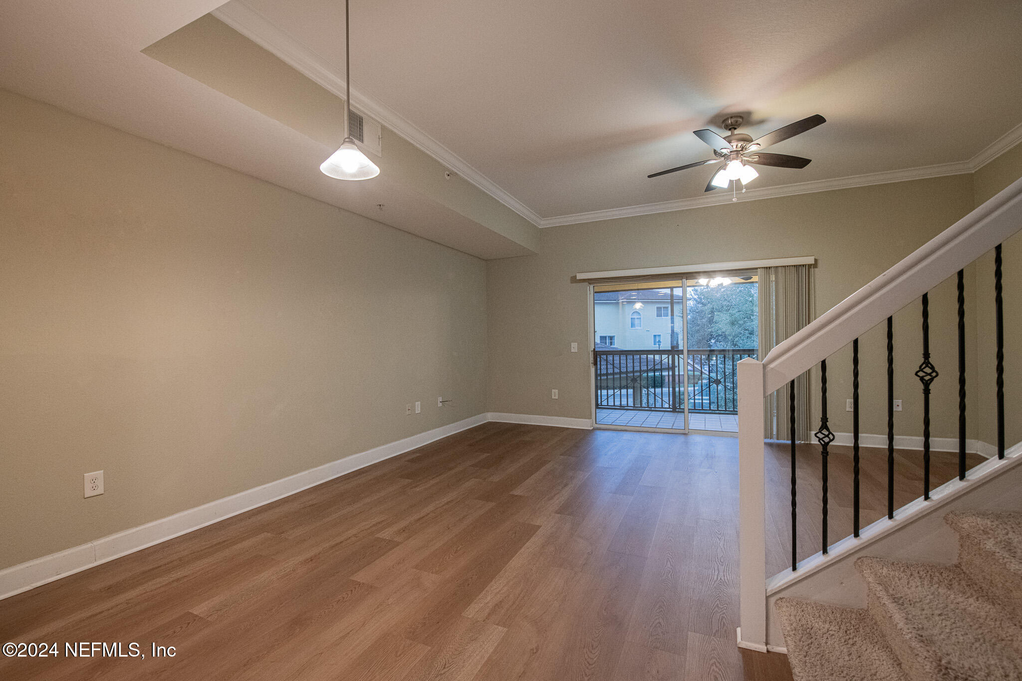9745 Touchton Road, Unit 1922 Jacksonville, FL 32246 - Photo 6 of 26 a view of an empty room with wooden floor and a ceiling fan