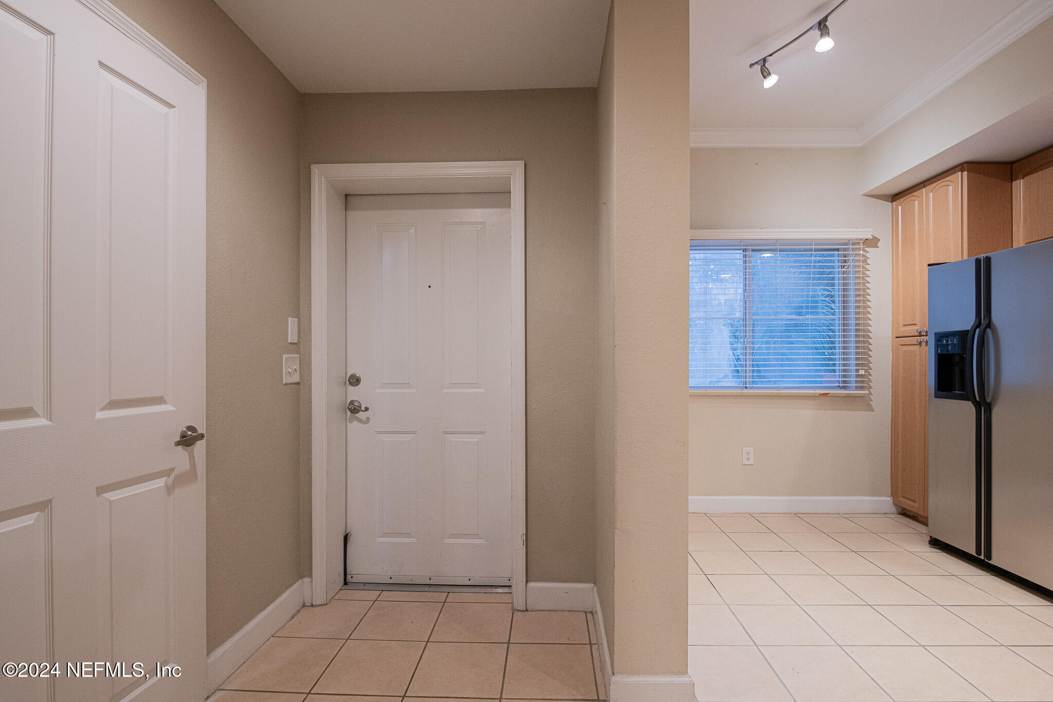 9745 Touchton Road, Unit 1922 Jacksonville, FL 32246 - Photo 8 of 26 a view of a refrigerator in kitchen and an empty room in wooden floor