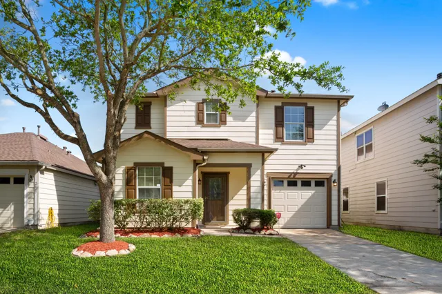 a front view of a house with a yard and green space