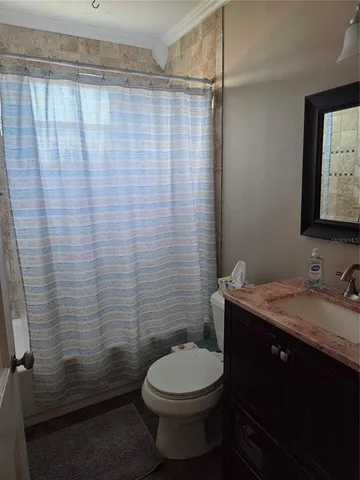 a bathroom with a granite countertop toilet sink and shower