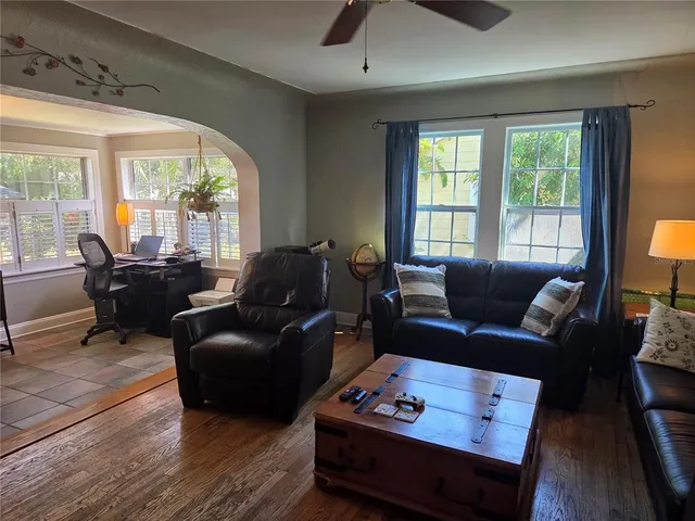 a living room with furniture fireplace and large windows
