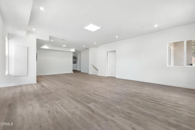 a view of an empty room with wooden floor