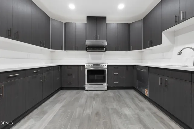 a kitchen with stainless steel appliances a sink and a refrigerator