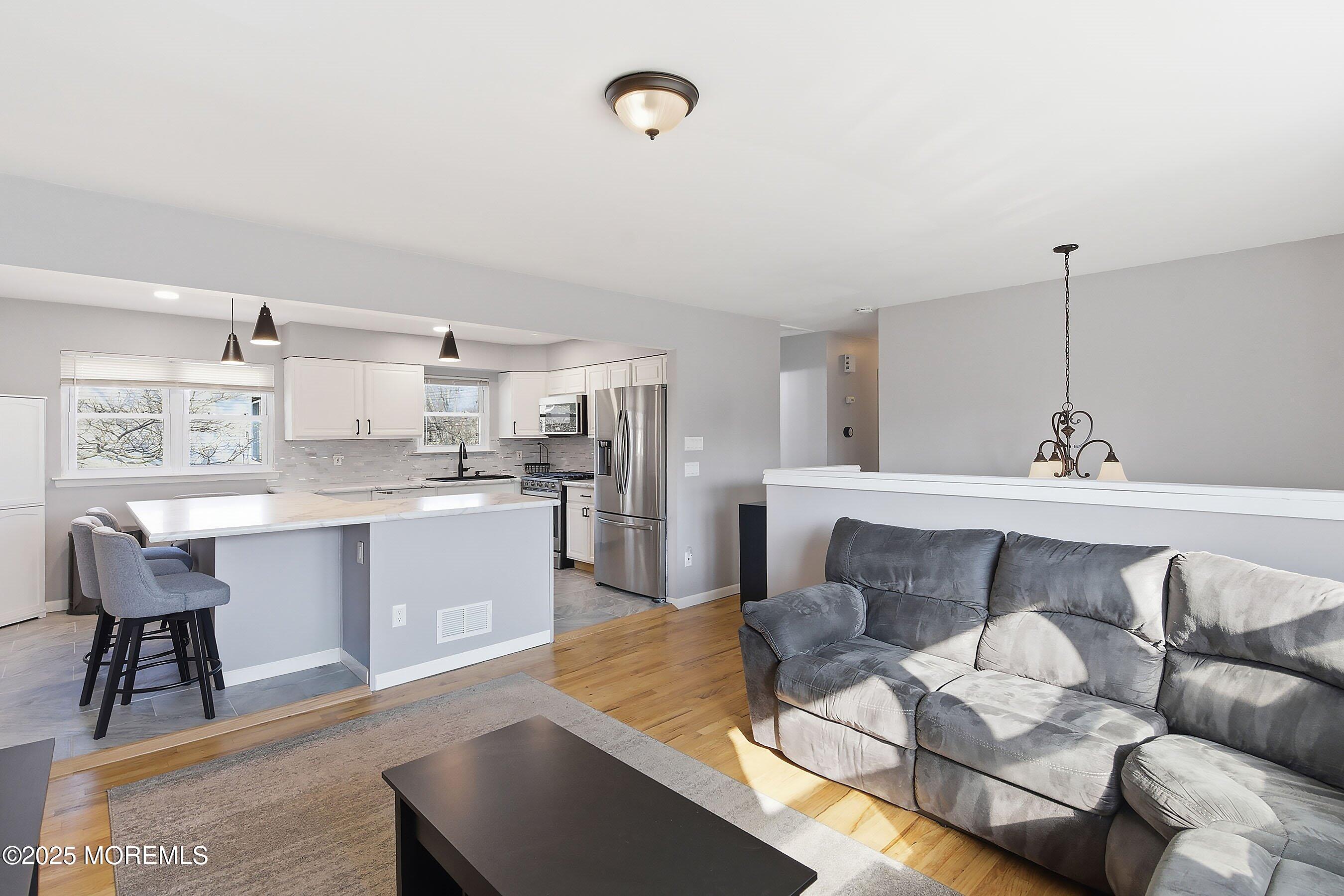 2178 Lanes Mill Road Brick, NJ 08724 - Photo 9 of 34 a living room with stainless steel appliances kitchen island granite countertop furniture and a wooden floor
