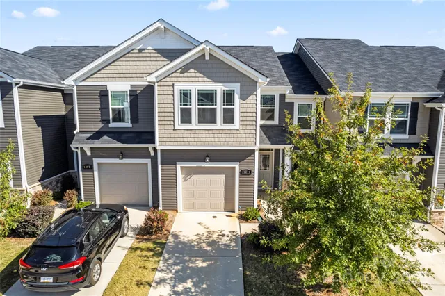 a view of a house with a yard and potted plants