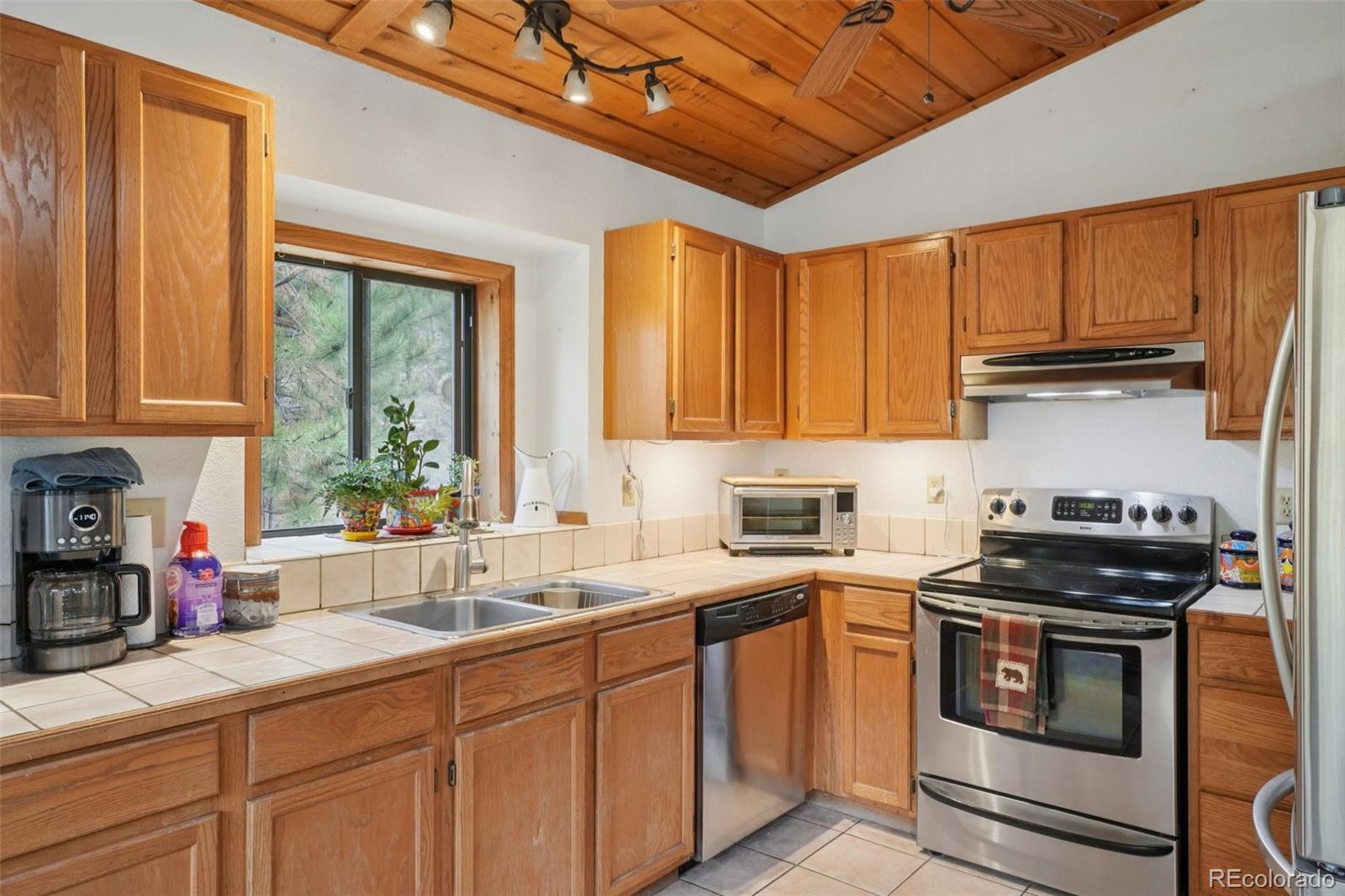 42 Catamount Ridge Road Bailey, CO 80421 - Photo 10 of 36 a kitchen with stainless steel appliances a stove a sink a cabinets and a window