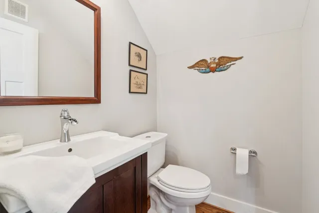 a bathroom with a sink mirror and toilet