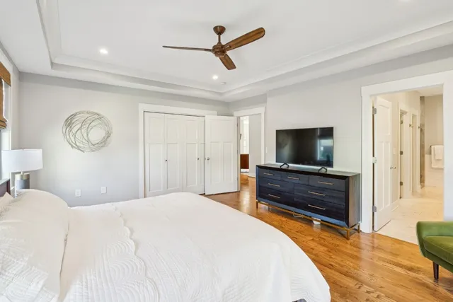 a bedroom with a bed a flat screen tv and a dresser