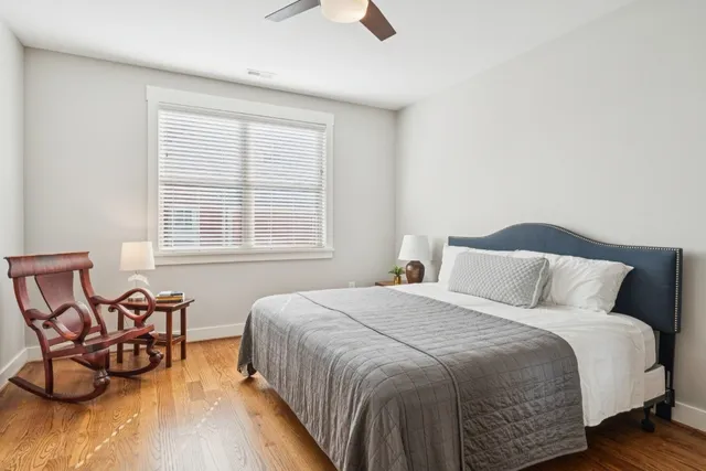 a large bed sitting in a bedroom next to a window and chair