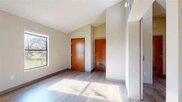 an empty room with windows and closet
