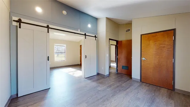 a view of empty room with wooden floor and closet area