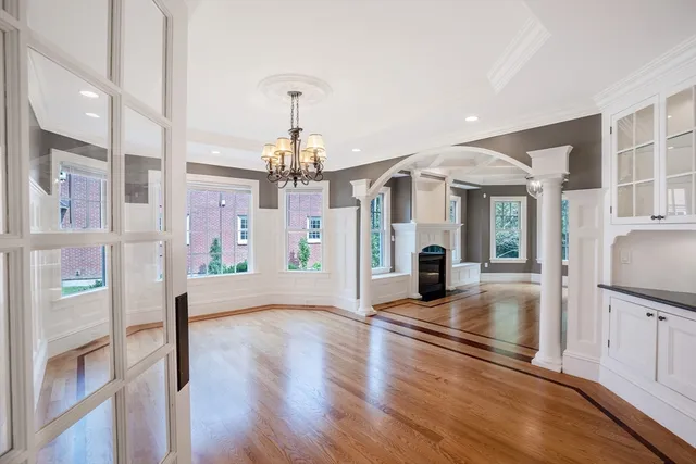 a view of a living room and livingroom with furniture wooden floor kitchen view and a chandelier