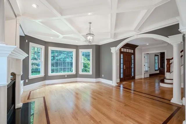 a view of an empty room with window and wooden floor