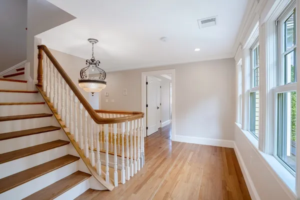 a view of a hallway with wooden floor and staircase