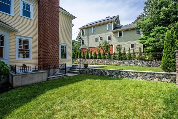 a view of house with a yard and sitting area