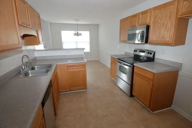 a kitchen with stainless steel appliances granite countertop a sink stove and microwave