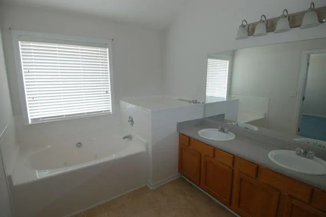 a bathroom with a granite countertop sink mirror toilet and bathtub