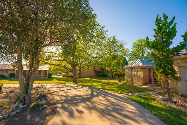 a view of a house with garden and trees