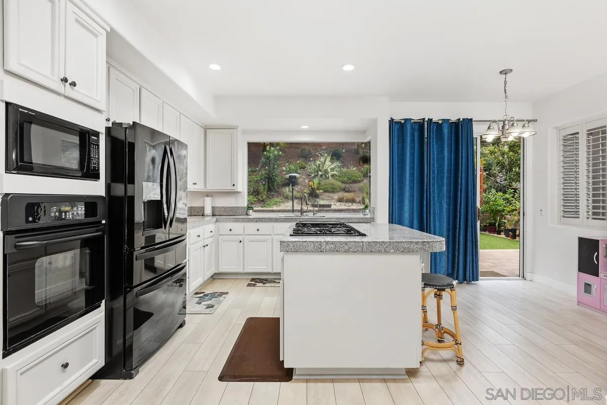 13847 Carmel Ridge Road San Diego, CA 92128 - Photo 11 of 40 a kitchen with a stove a sink and a microwave
