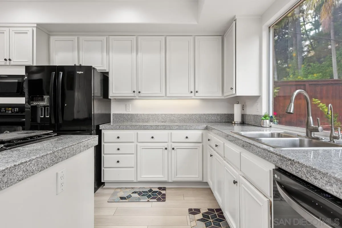 13847 Carmel Ridge Road San Diego, CA 92128 - Photo 13 of 40 a kitchen with granite countertop a sink stove and cabinets