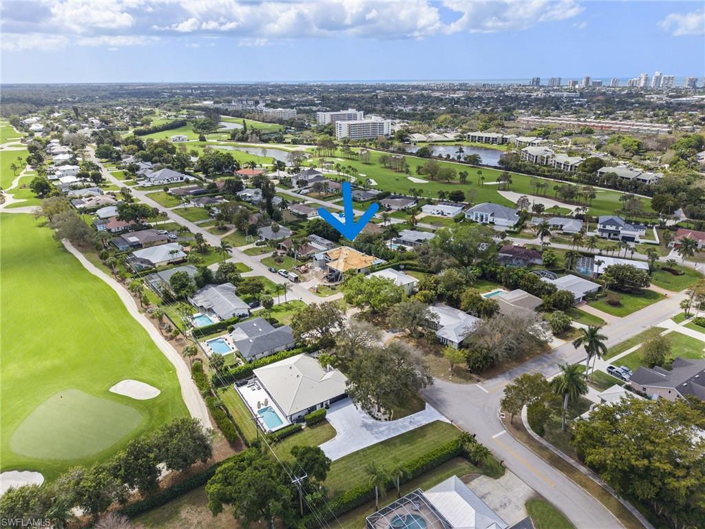 335 Burning Tree Drive Naples, FL 34105 - Photo 21 of 27 Aerial perspective of suburban area featuring a golf course and a nearby body of water