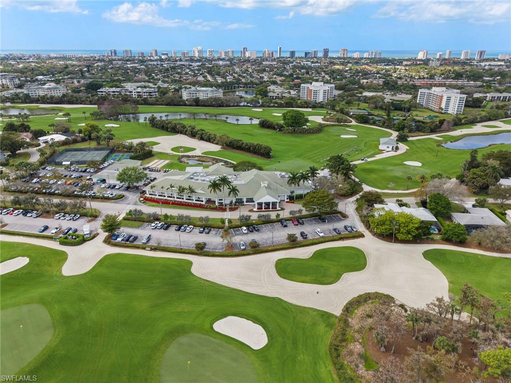 335 Burning Tree Drive Naples, FL 34105 - Photo 22 of 27 Aerial view of a golf club, a large body of water, and skyline