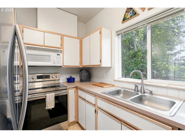 a kitchen with stainless steel appliances a sink stove and cabinets