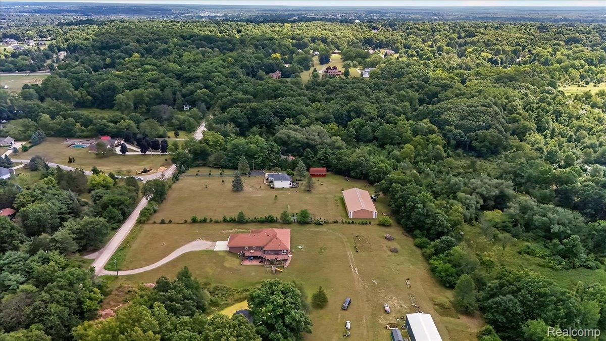 7330 West Gates Street Romeo, MI 48065 - Photo 63 of 73 Expansive property featuring a brick residence, a large outbuilding with a metal roof, and a separate red structure
