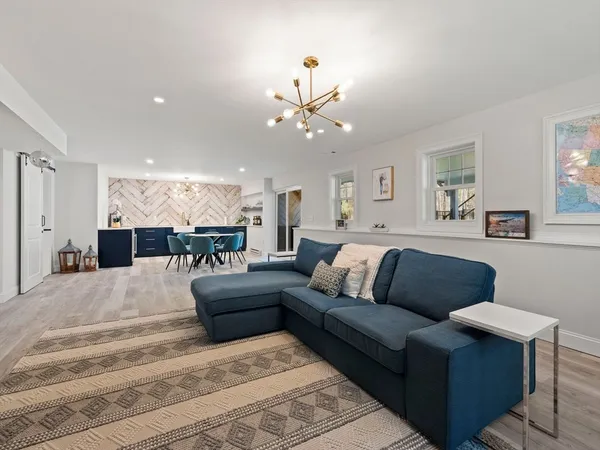 a living room with furniture and a chandelier