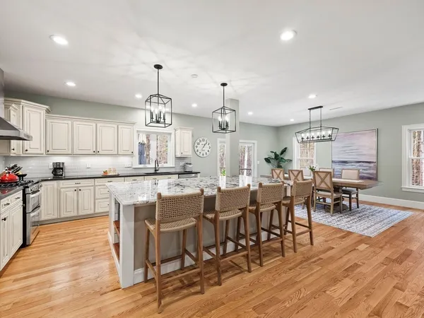 an open kitchen with kitchen island wooden floors and center island