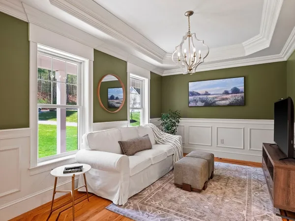 a living room with furniture a chandelier and a flat screen tv