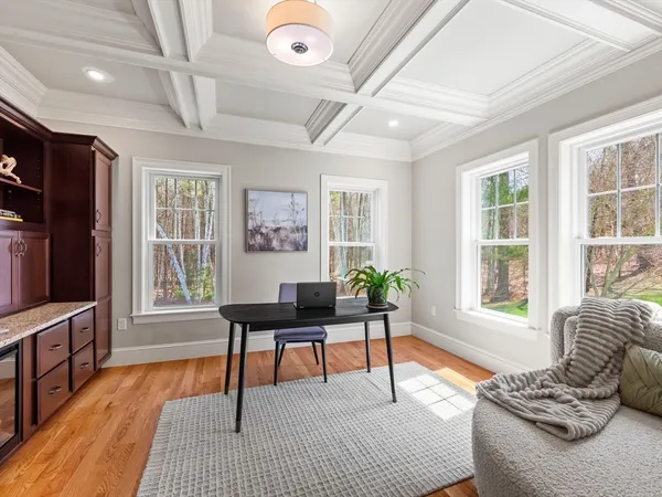 a living room with furniture two window and wooden floor