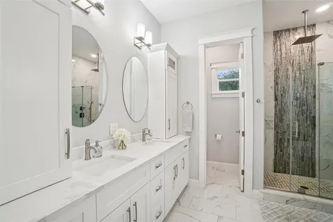 a bathroom with double vanity sinks and a mirror