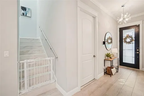 a living room with furniture a large window and a chandelier