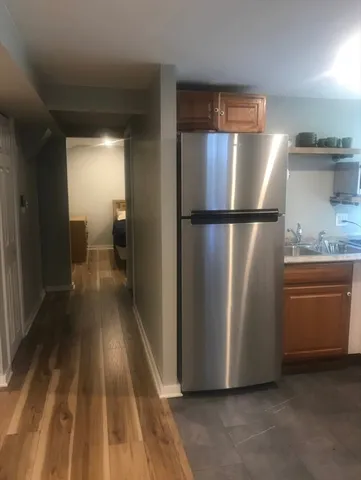 a view of a kitchen with a refrigerator wooden floor and a sink