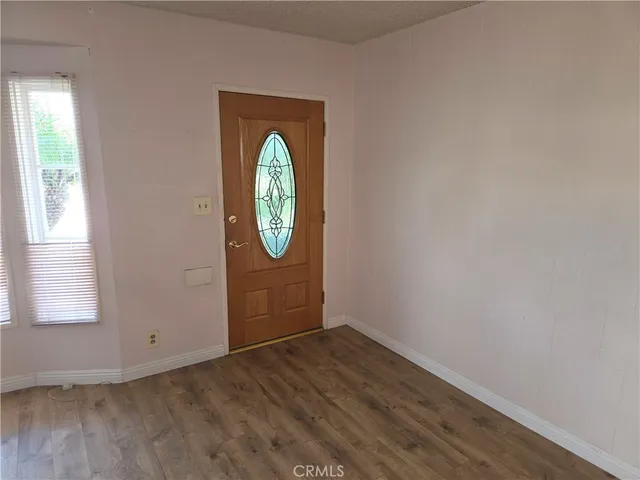 a view of an empty room with a fireplace and a window