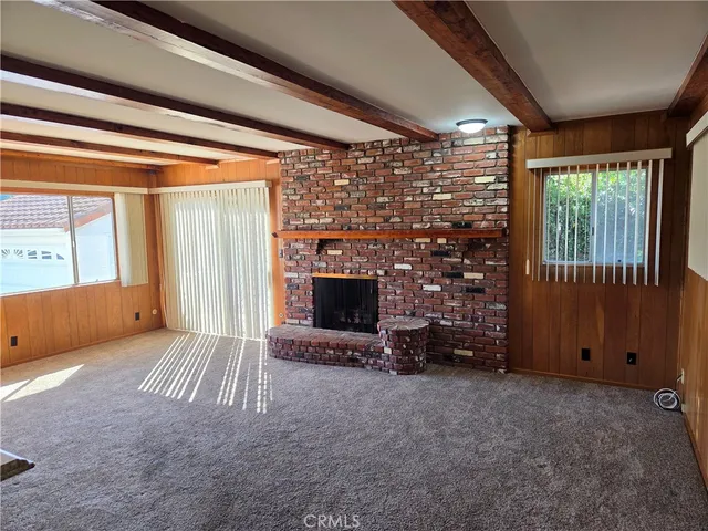 a view of empty room with wooden floor and fireplace