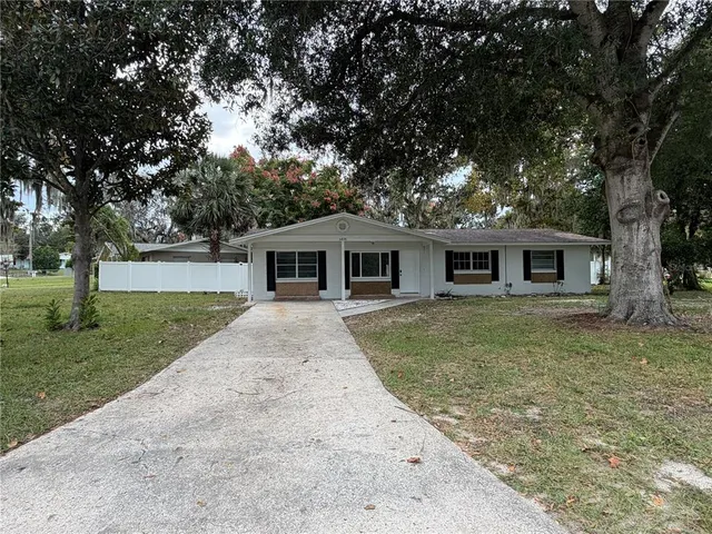 a front view of a house with a garden and trees