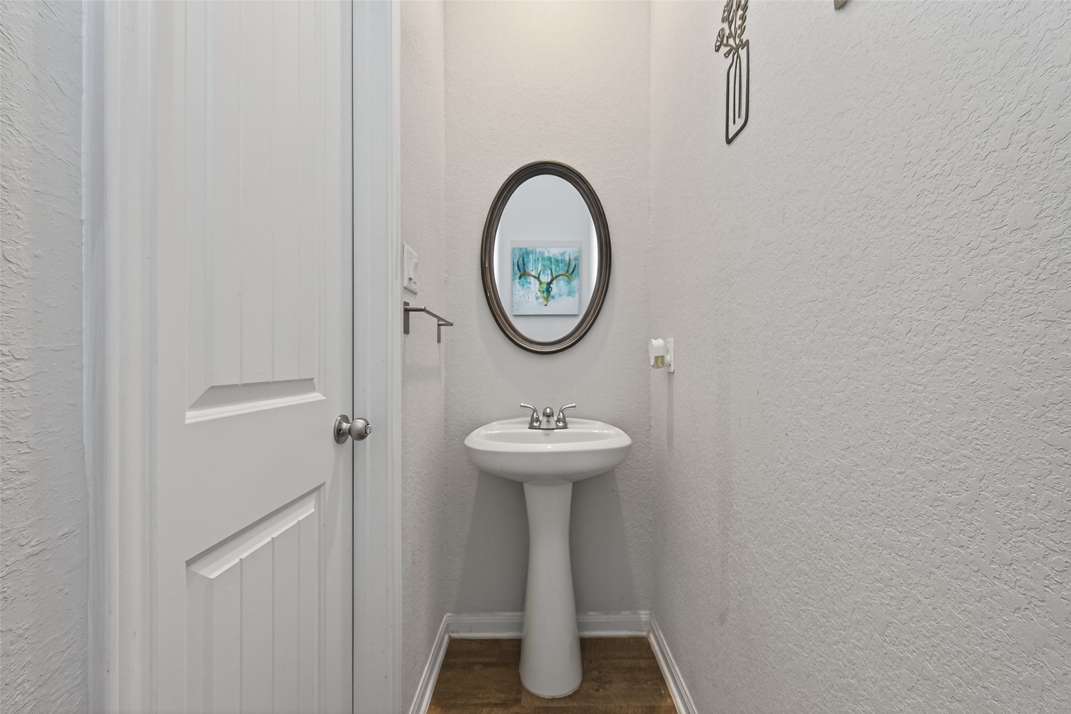 16601 Crosby Street Conroe, TX 77303 - Photo 20 of 50 Convenient powder room featuring a pedestal sink, neutral finishes, and decorative touches—perfect for guests.