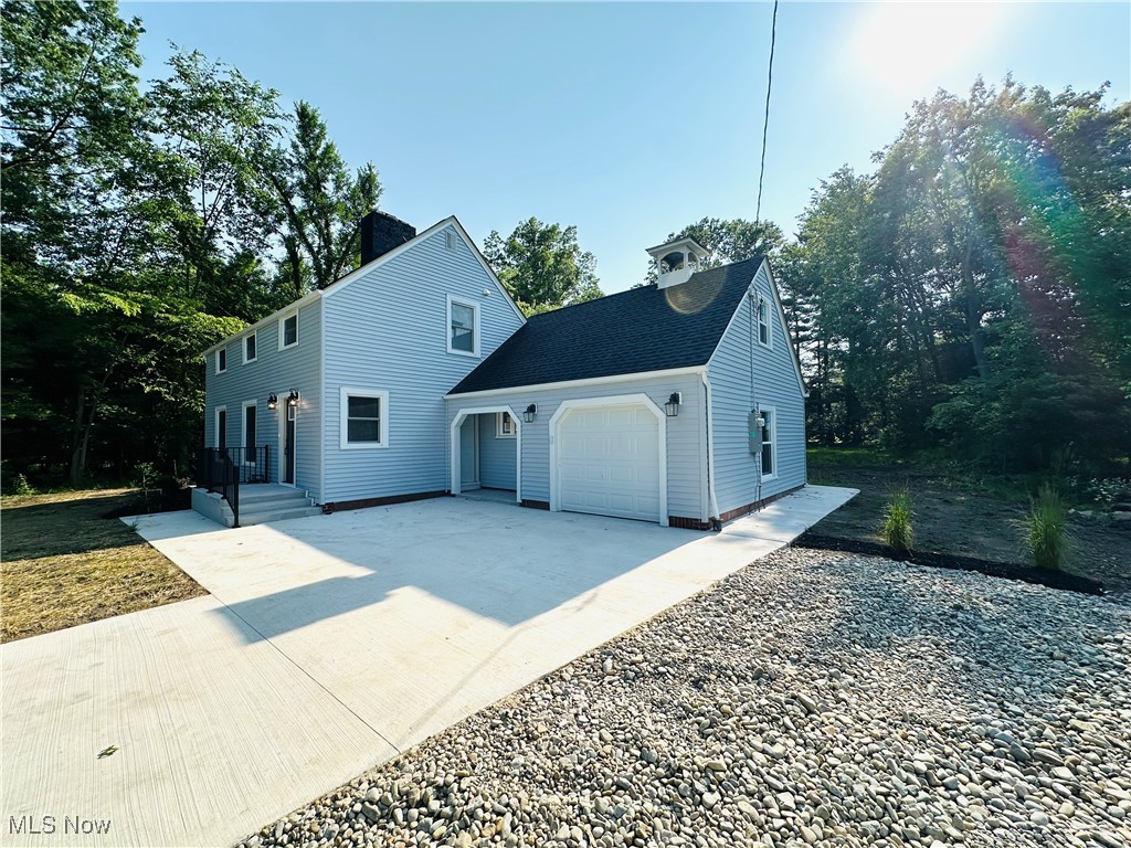 568 North Road Southeast Warren, OH 44484 - Photo 12 of 49 View of front of home featuring an attached garage, rand new concrete driveway, a chimney, and roof with shingles