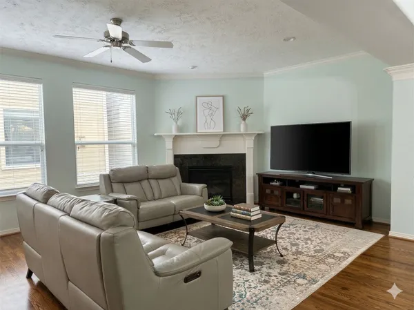 a living room with furniture a flat screen tv and a fireplace