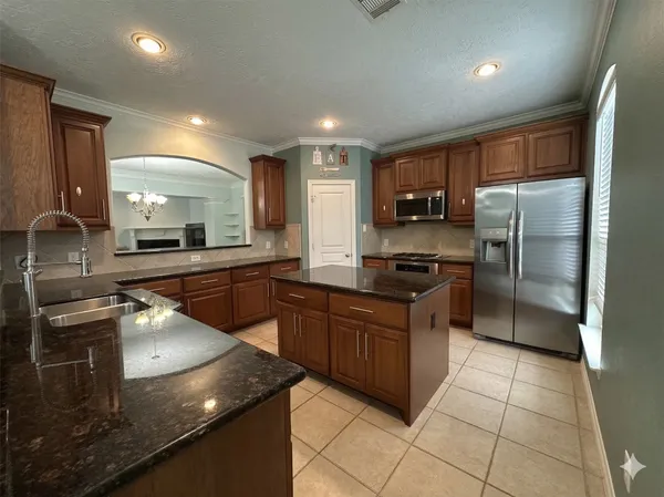 a kitchen with stainless steel appliances granite countertop a sink a stove and a refrigerator
