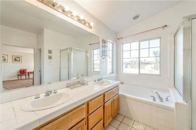 a bathroom with a tub a double vanity sink and mirror