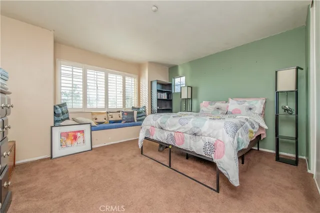 a spacious bedroom with a bed and a large window