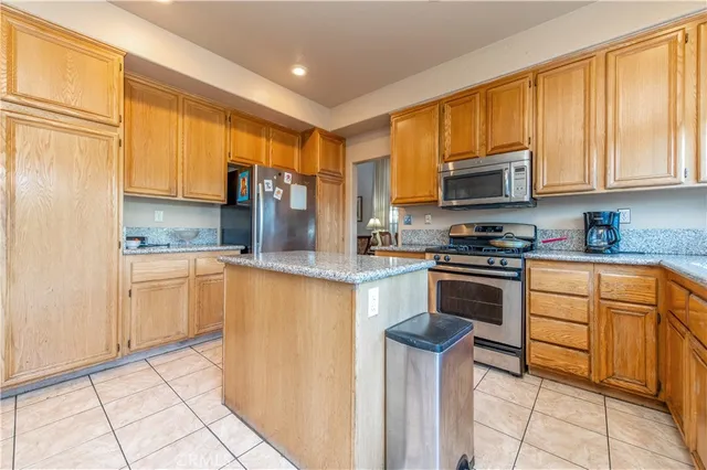 a kitchen with granite countertop a refrigerator stove top oven and sink