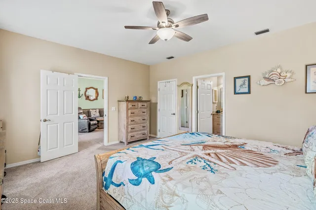 a bedroom with a bed chandelier and a window