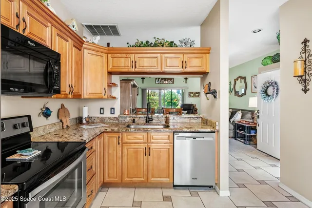 a kitchen with a stove top oven a sink a counter top space and cabinets